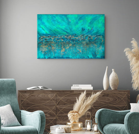 An abstract canvas painting with vibrant turquoise, teal, and gold brushstrokes, displayed on a gray wall above a dark wood console table in a styled living room setting. Equinox, Original Canvas Painting by Julie Bevan