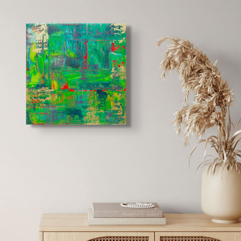 Abstract painting on a wall above a wooden cabinet with a vase and samhain no 3
books.