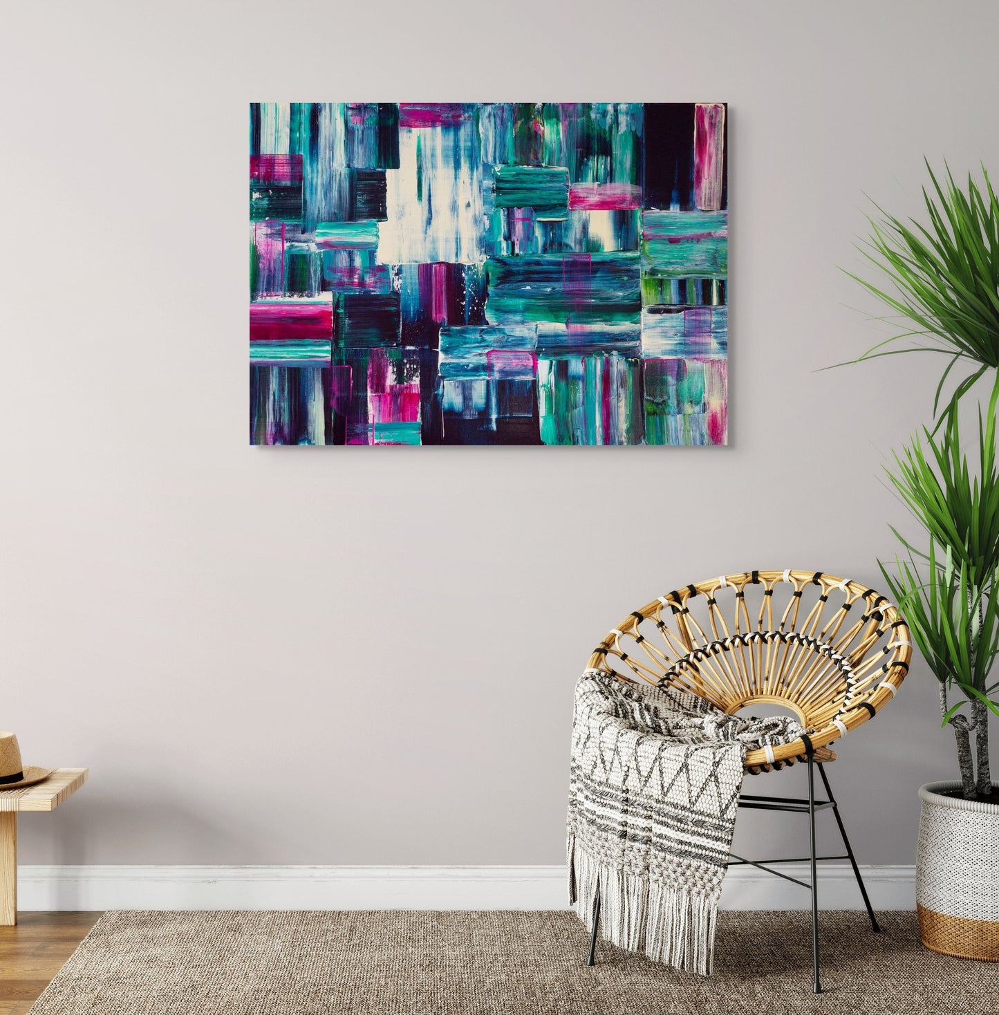 Abstract art painting on a wall above a chair with a plant in the corner.