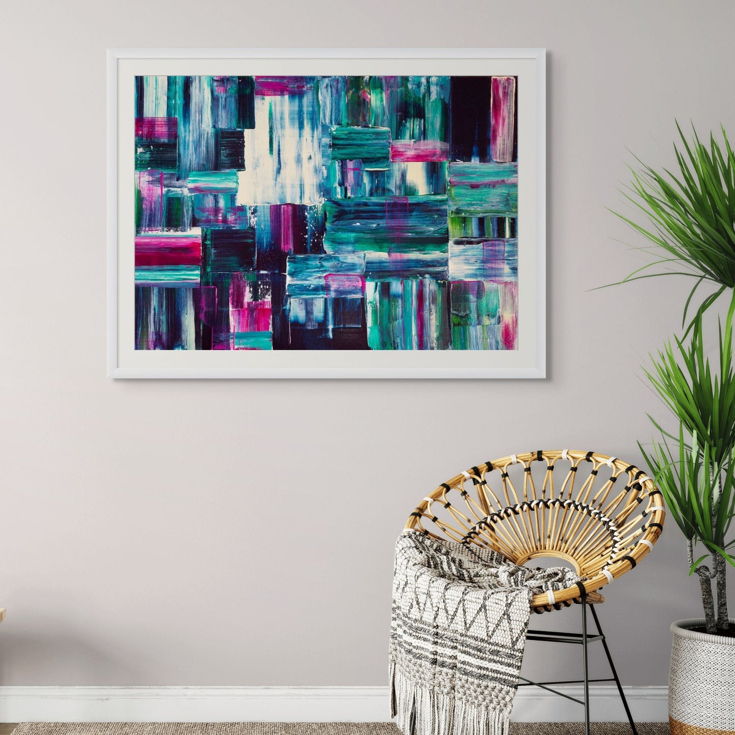 Abstract art piece on a wall above a chair with a plant in the corner.