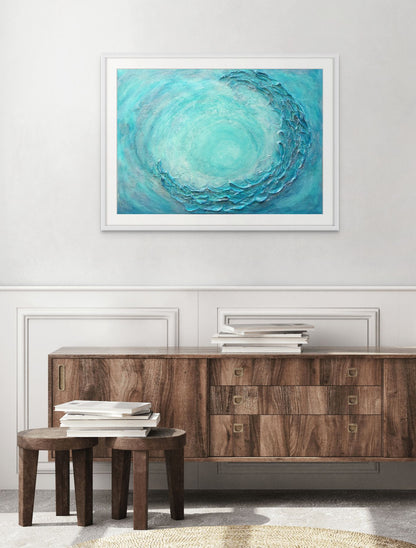 Framed abstract art piece with concentric circles in blue and green above a wooden console table.