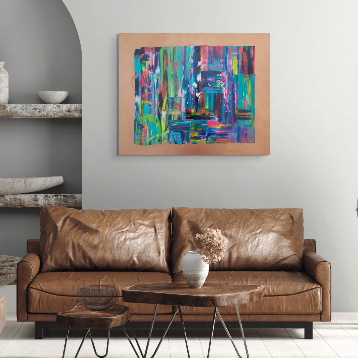 Brown leather sofa in a living room with a colorful abstract painting on the wall. Tao an original abstract canvas painting by Julie Bevan