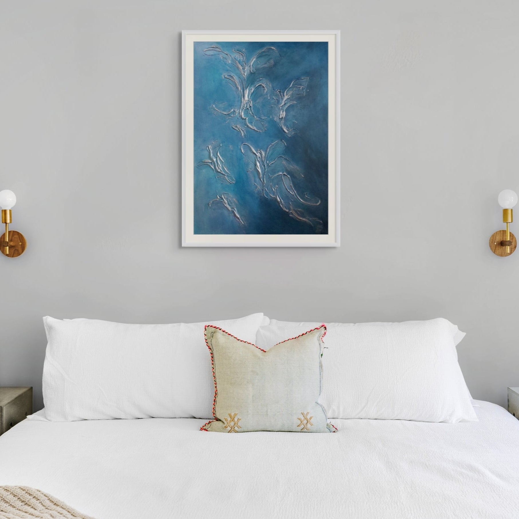 Bedroom with a bed, nightstands, and blue abstract limited edition print artwork on a gray wall.