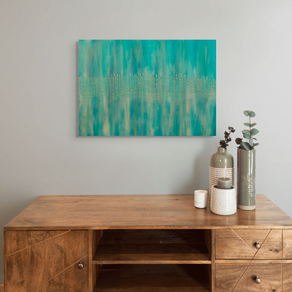 Wooden desk with decorative items and a teal abstract painting on the wall.titled Golden Forest by Julie Bevan