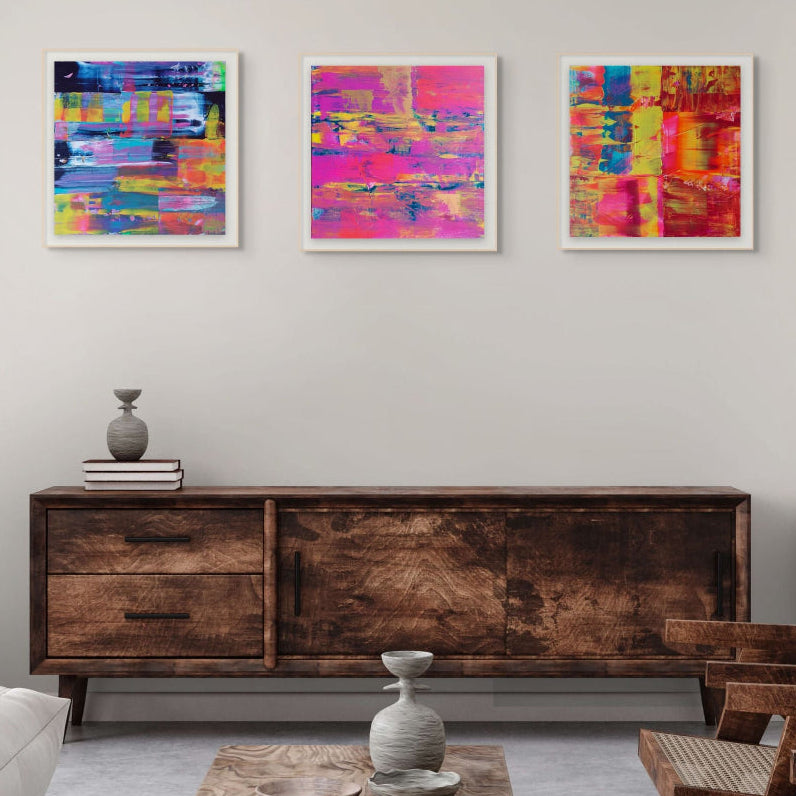 Modern living room with wooden furniture, with three fine art colourful prints, flurry, Denim and Midnight By Julie Bevan Art