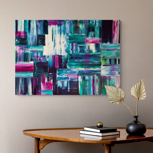 Abstract colorful painting on a wall above a wooden table with decor items.