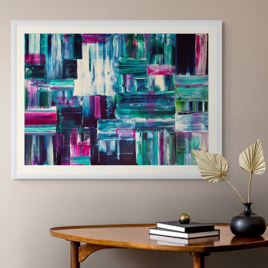 Abstract art print on a wall above a wooden table with decor items.