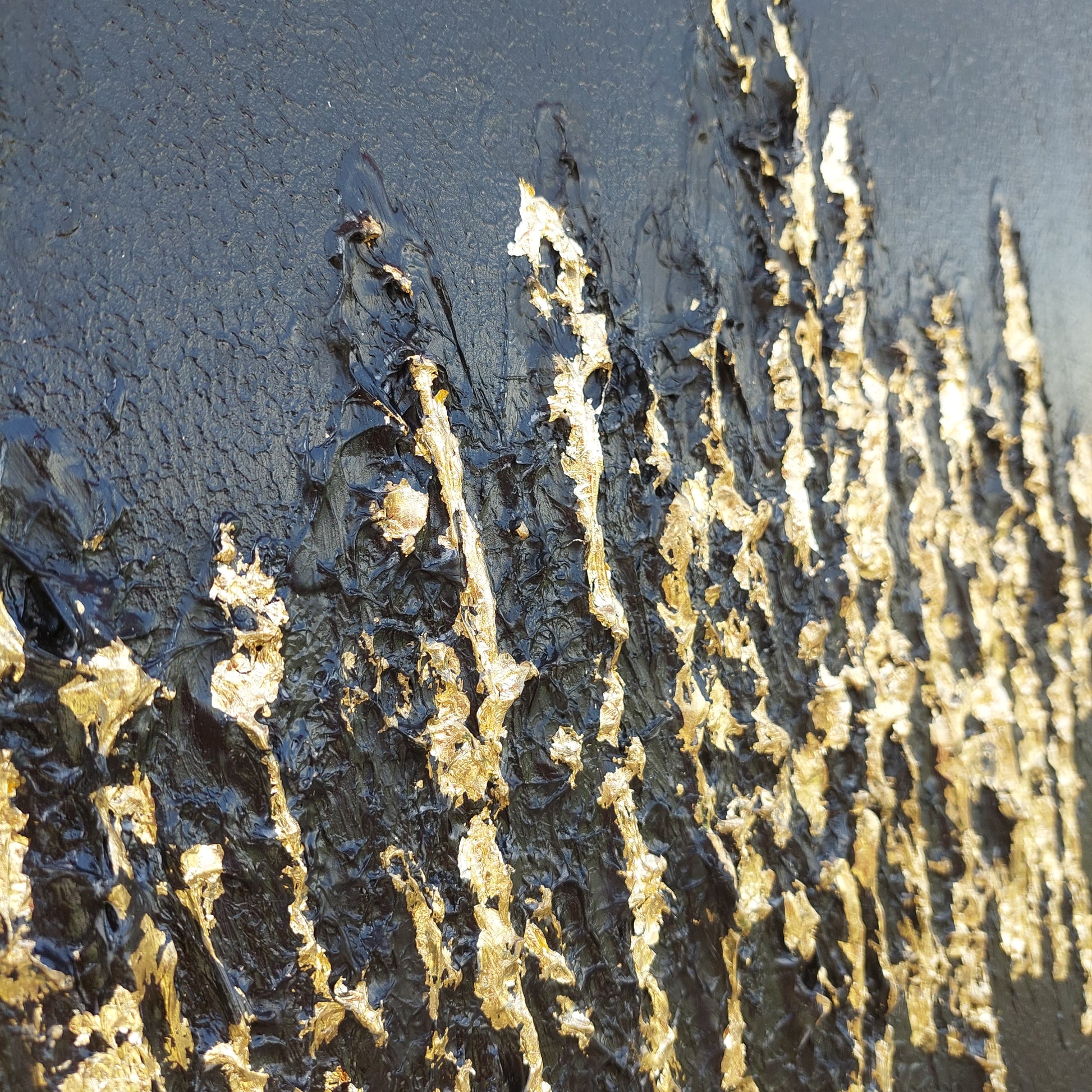 Close up Black textured painting with gold leaf overlay