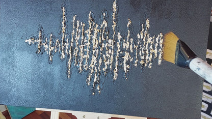 video of close up brushing gold leaf off painting