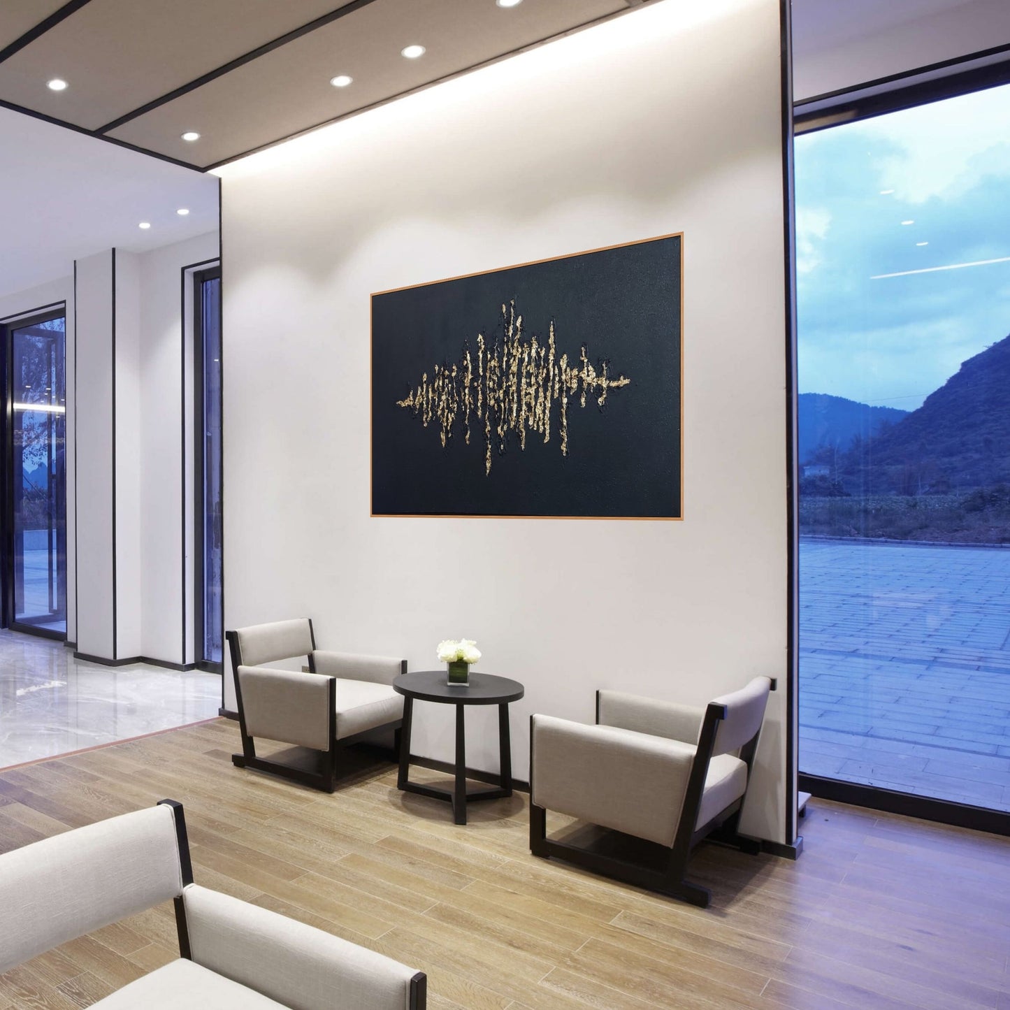 Black textured painting with gold leaf overlay in a hotel lobby